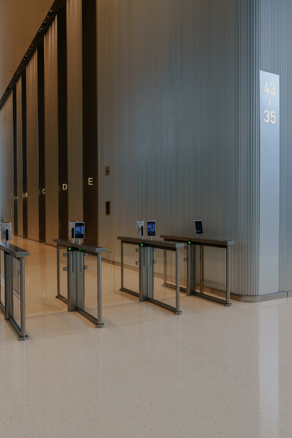 Glastüren-Drehkreuze stehen in einer modernen Büro-Lobby.