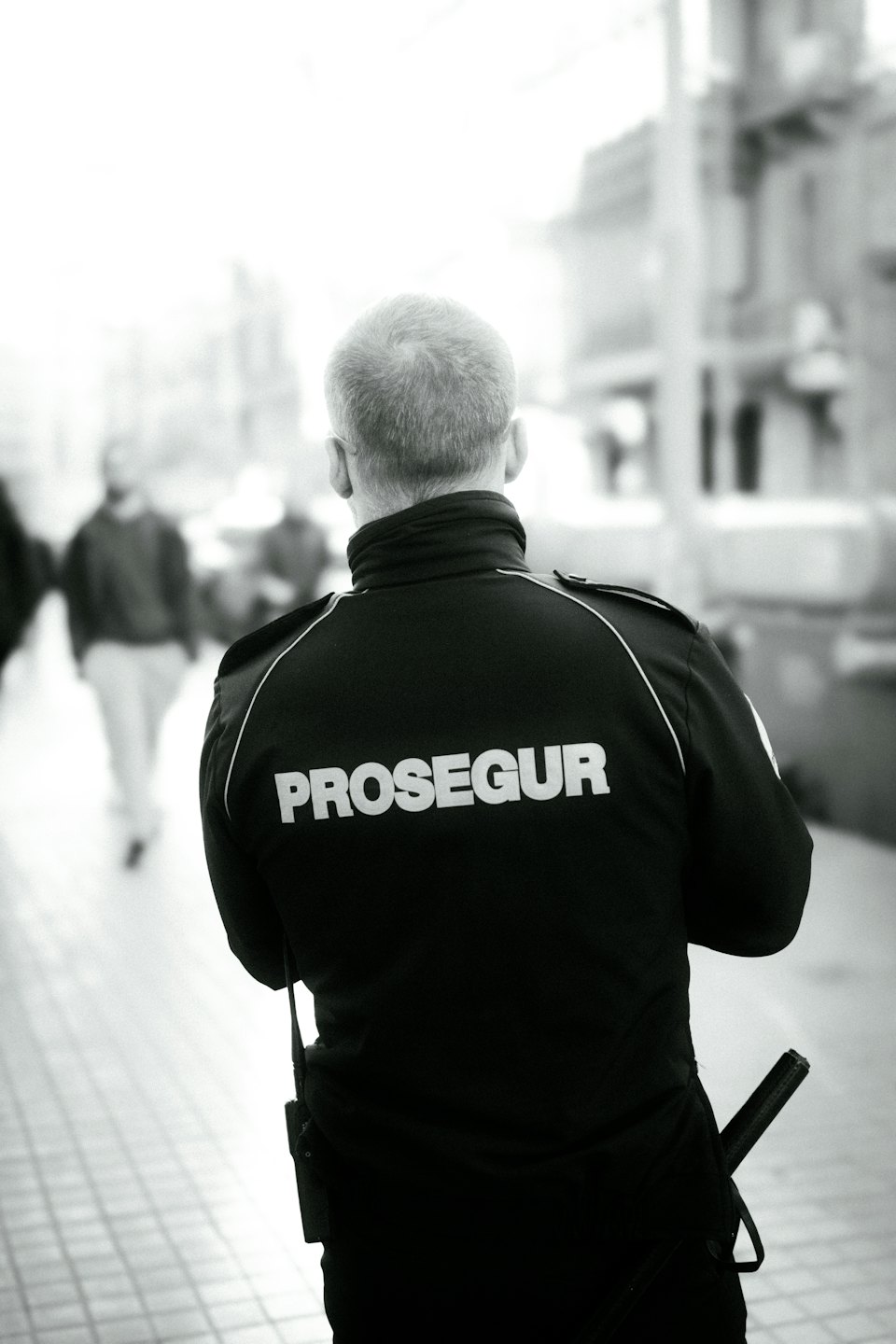 Sicherheitsmitarbeiter in Prosegur-Jacke auf der Straße.